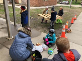 Three hedgehog students bring over the large pallet to begin construction of the Music Wall.