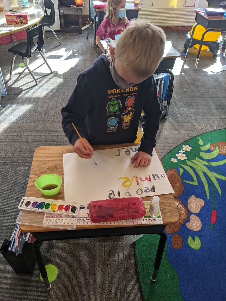 Omer painting his word wall words.